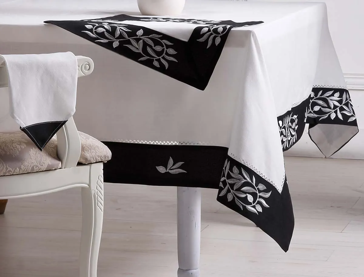 Retailers reviewing an embroidered tablecloth in a textile showroom